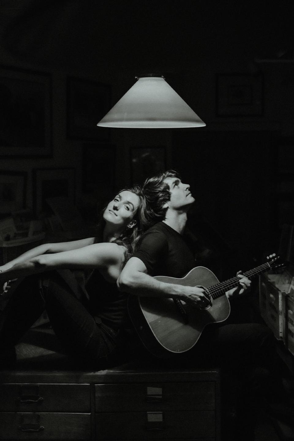 Devon and Linnea Seegers with a guitar beneath a studio lamp